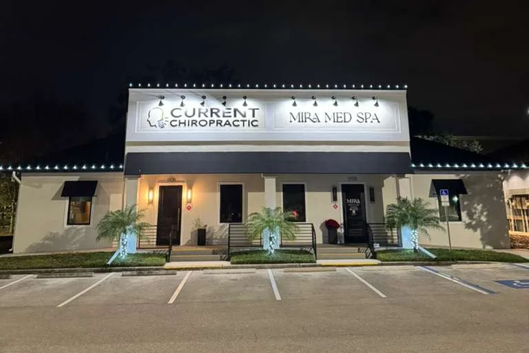 Nighttime storefront with warm white rooflines lighting for Current Chiropractic and Mira Med Spa
