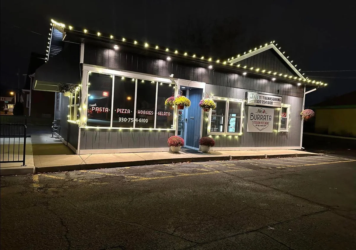 Warm white Christmas lighting along the roofline of an Italian restaurant storefront