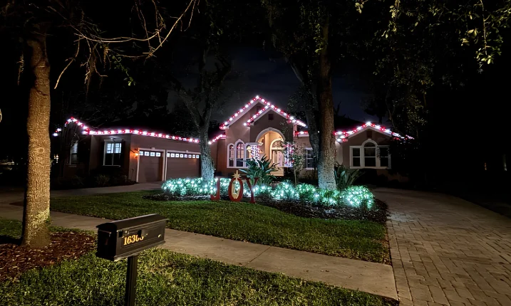 Ranch home with pink and white roofline Christmas lighting