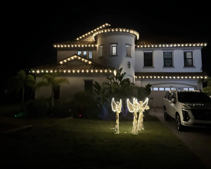 Mediterranean-style estate with roofline lighting and lit angel decor