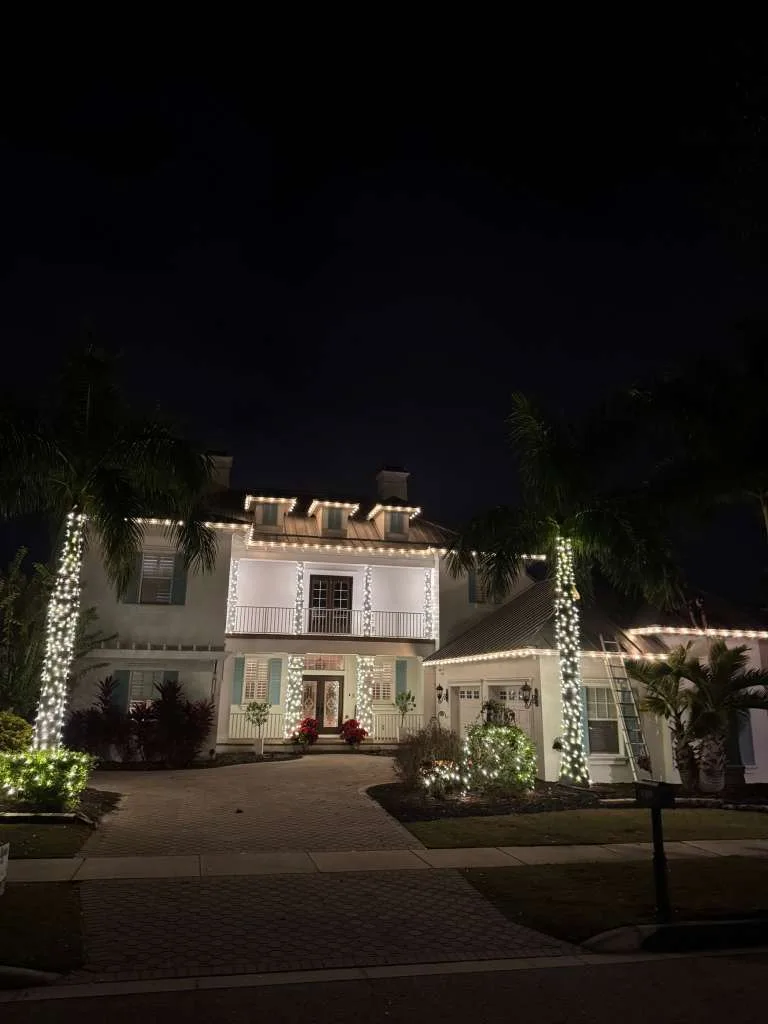 Two-story estate home in Apollo Beach, FL with warm white roofline Christmas lighting