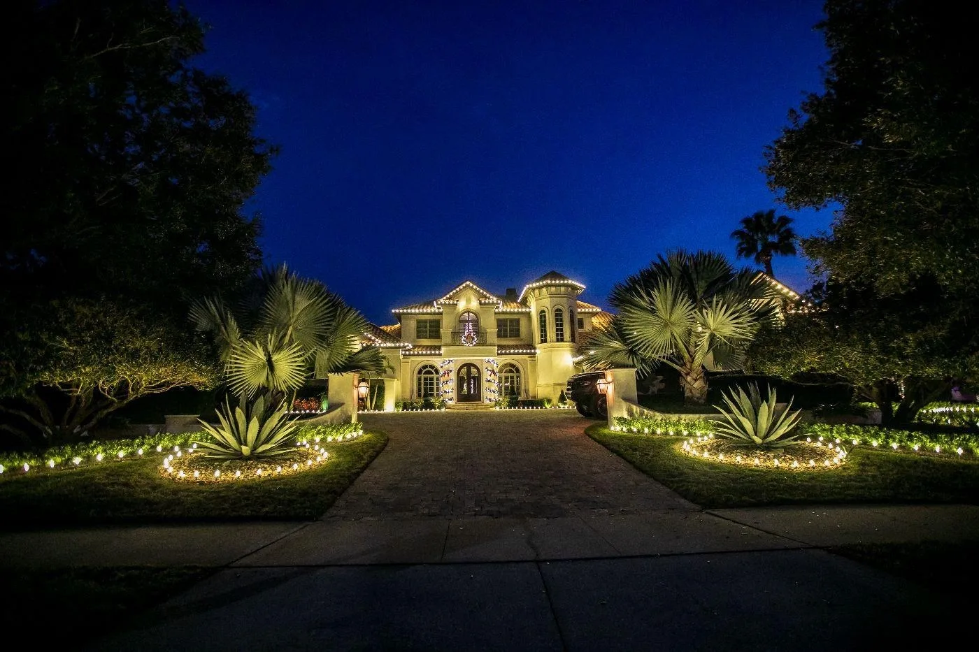 Large estate home on Davis Islands, FL with warm white roofline Christmas lighting and lit landscaping