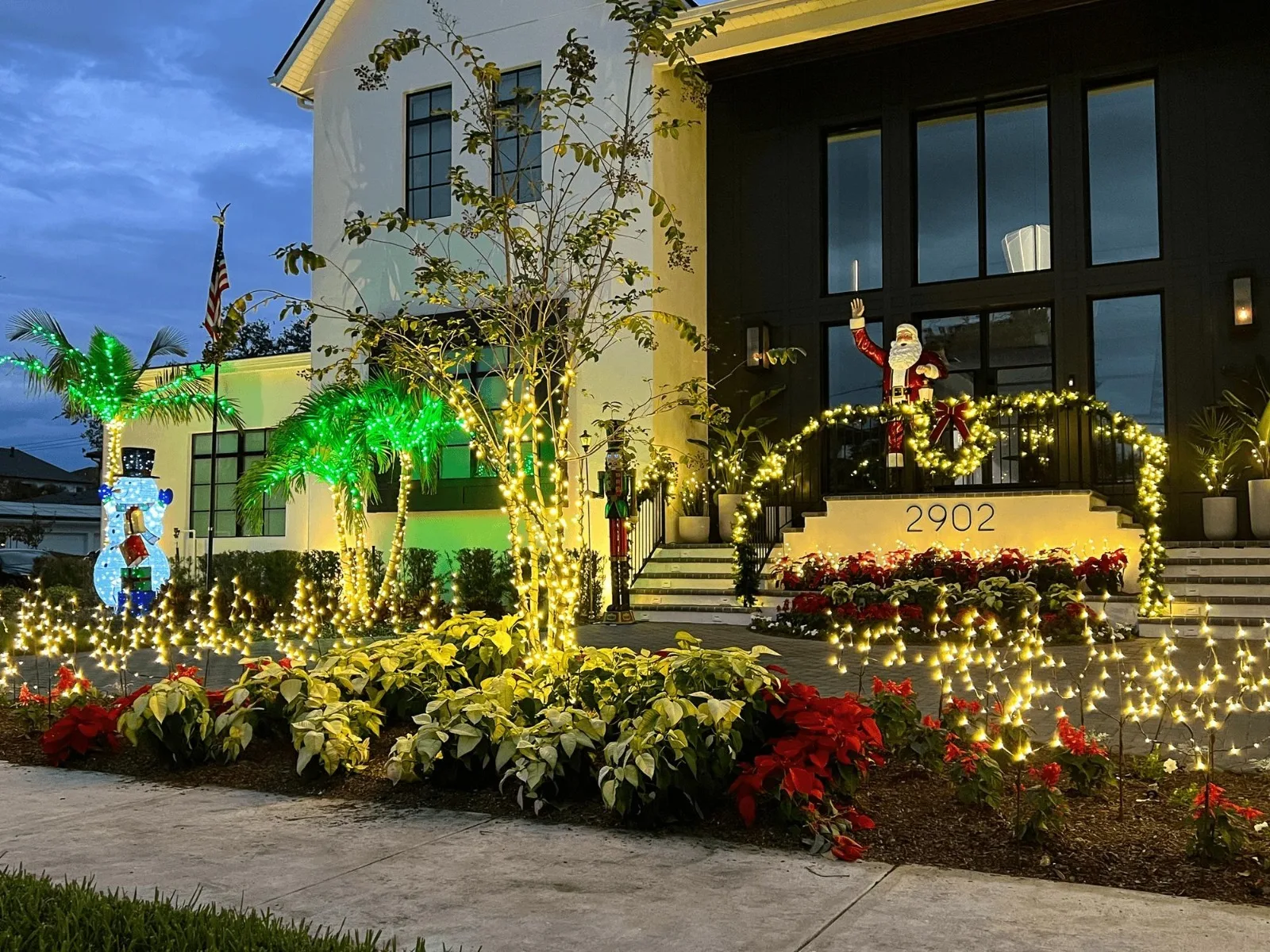 Modern home on Davis Islands, FL with warm white Christmas lighting and holiday yard decor