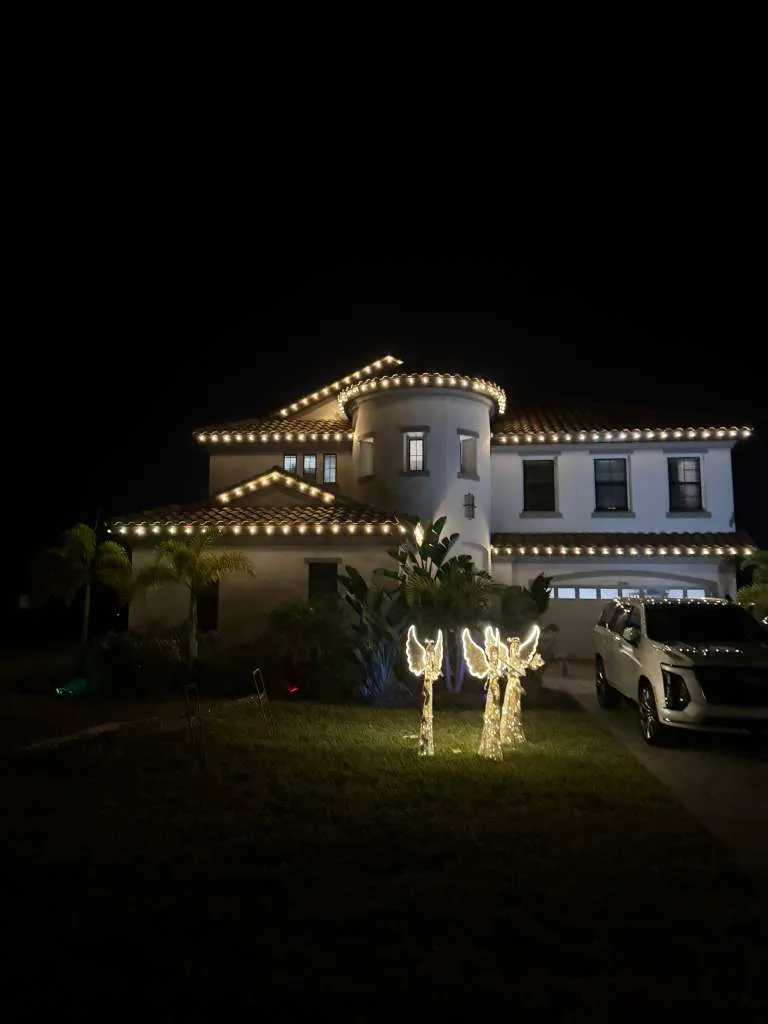 Estate home in FishHawk, FL with warm white roofline lighting and lit angel yard decor
