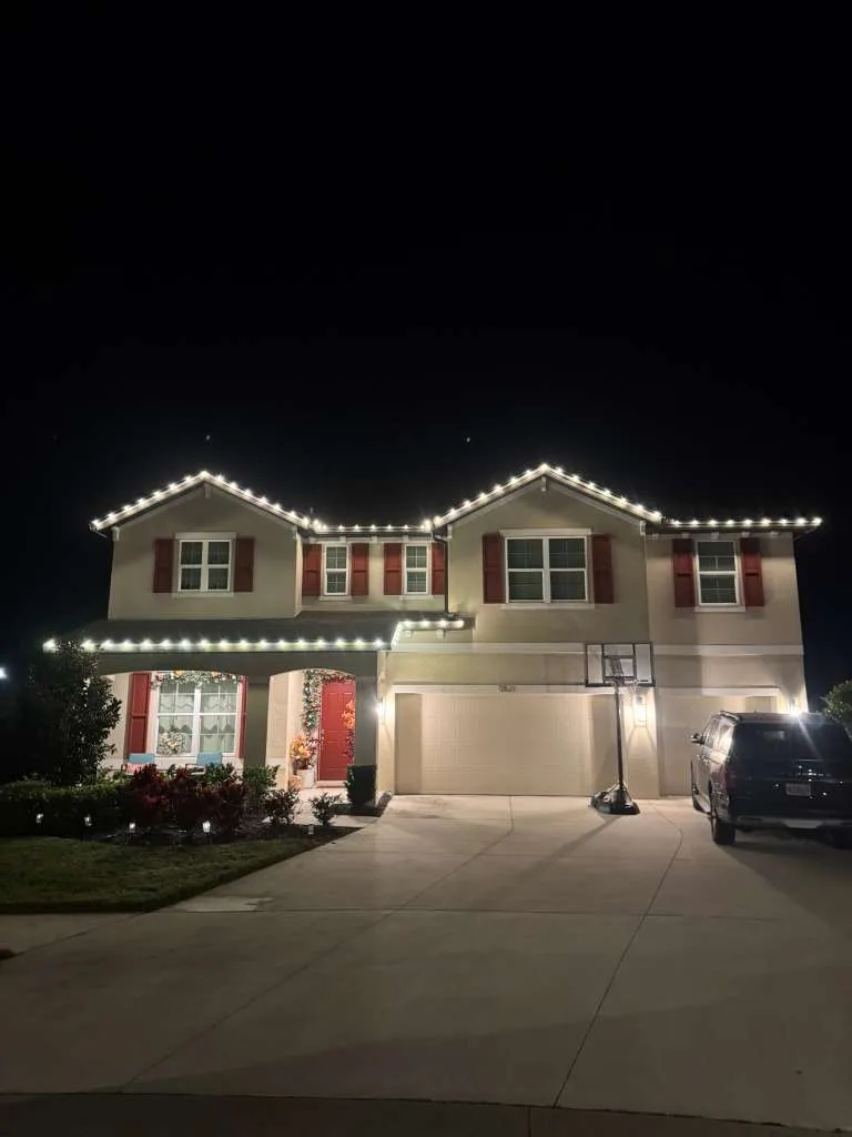Two-story home in Riverview, FL with warm white roofline Christmas lighting