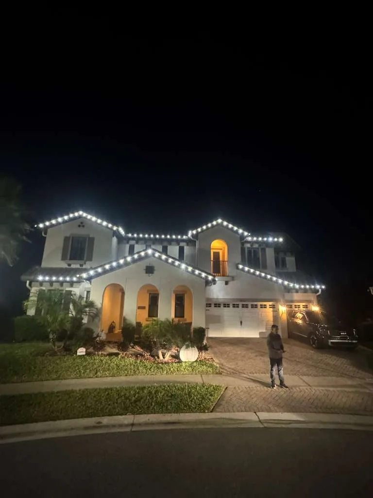 Two-story estate home in Tampa, FL with warm white roofline Christmas lighting