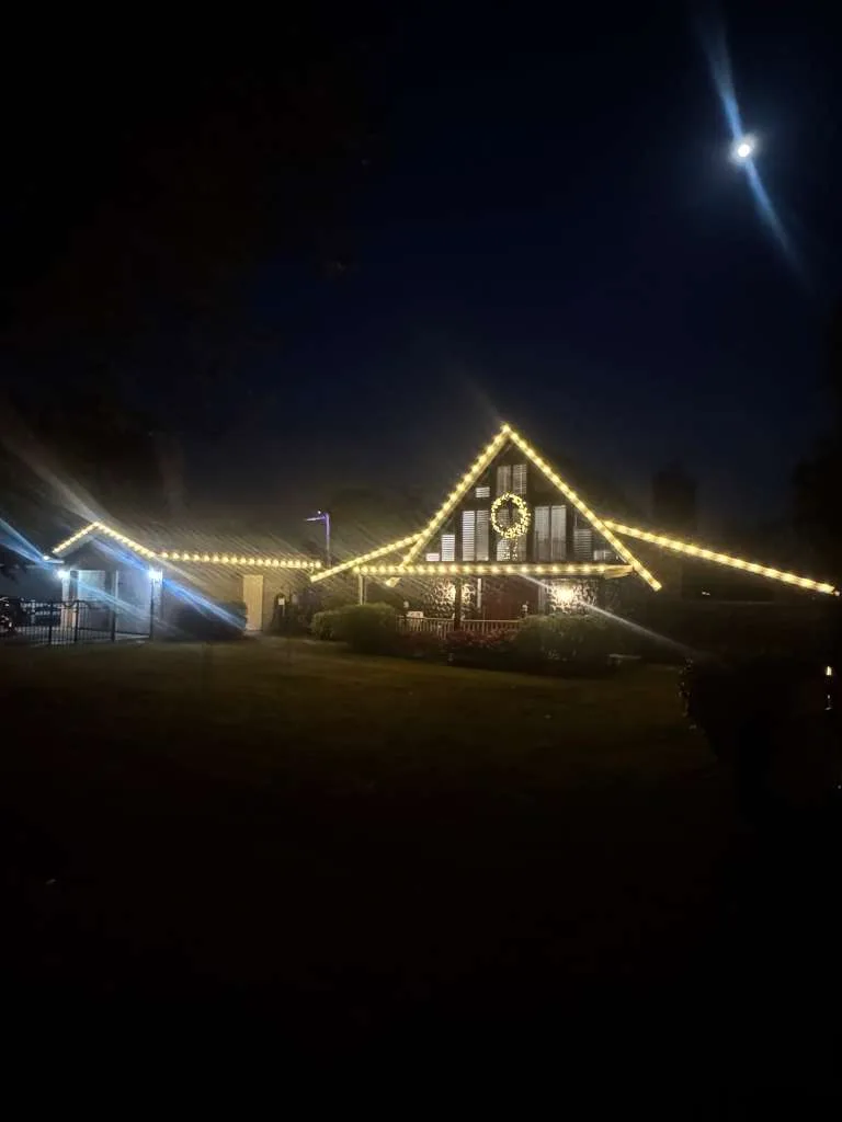 A-frame home in Valrico, FL with warm white roofline outline lighting and a lit wreath
